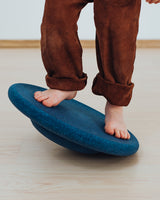Kind balanciert auf einem Stapelstein® Board dark blue