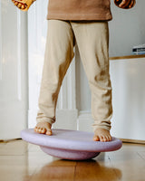 Kind balanciert auf einem Stapelstein® Board light violet