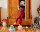 Kind seht auf Stapelstein® Inside rainbow pastel