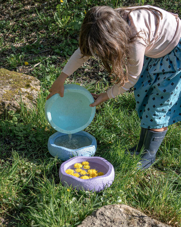 Kind spielt im Garten mit Stapelstein® Originals und Wasser