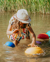 Kind spielt im Wasser mit Stapelstein Original und Inside