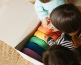 Kinder packen einen Stapelstein® rainbow classic aus einem Karton