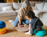 Oma und Kind spielen im Wohnzimmer mit den Stapelstein® Elementen