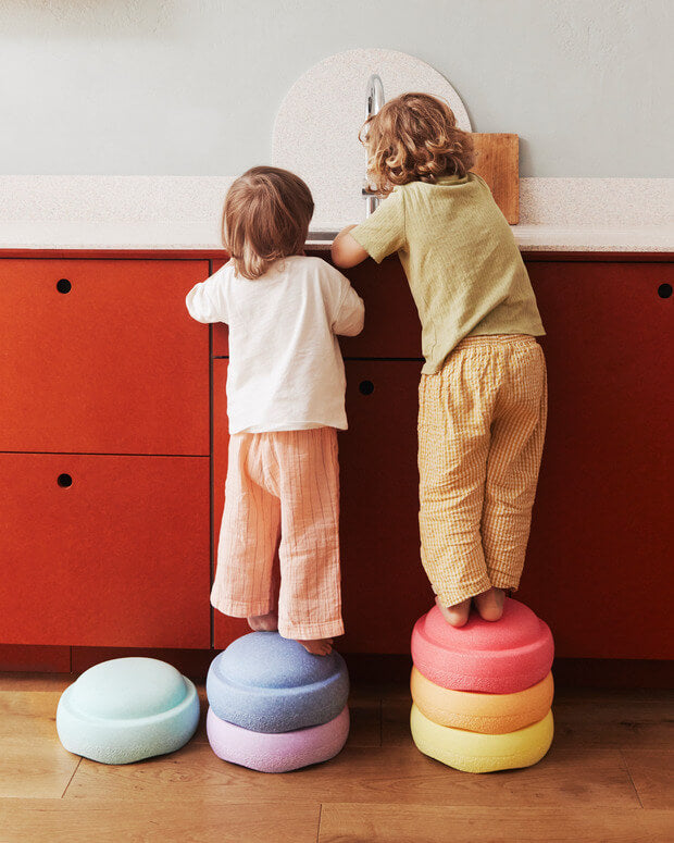 Kinder stehen in der Küche auf zwei kleinen Stapelstein® Türmen